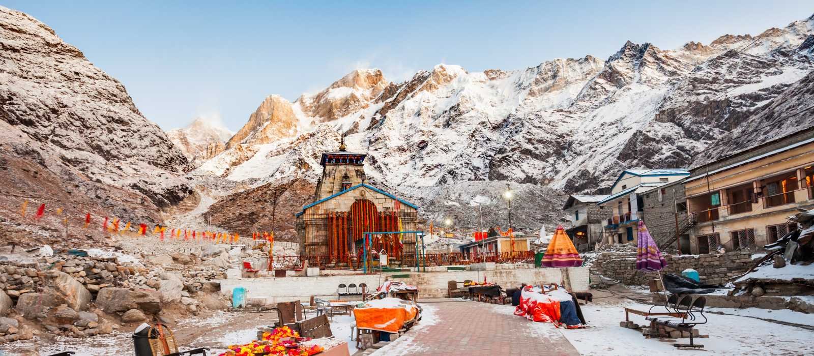 Kedarnath Temple with Himalayan mountains and hotels in the background, showing beautiful morning scenery